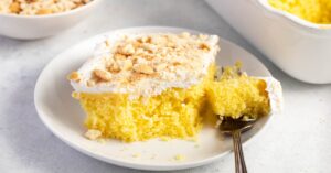 Banana Pudding Poke Cake with Crumbs in a White Plate