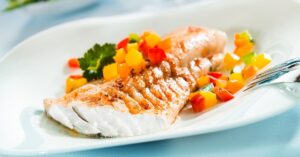 Homemade Haddock Fillet with Vegetables in a White Plate