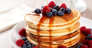 Homemade Pancakes with Blueberries Poured with Maple Syrup